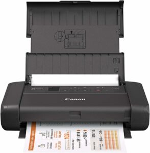 The Canon PIXMA TR150 printer with paper on it.