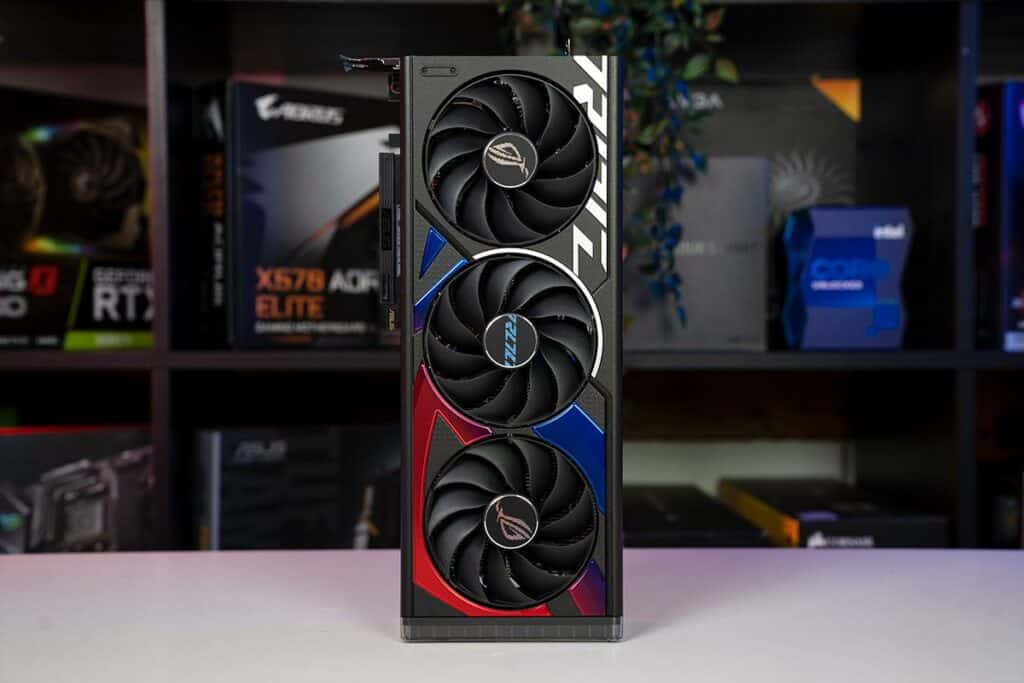 A high-performance triple-fan RTX 4060 graphics card displayed against a backdrop of PC component boxes.